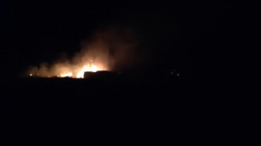Gece parlayan bir ateş, insanların siluetleri, itfaiyecilerin işi, yavaş çekim