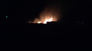 Gece parlayan bir ateş, insanların siluetleri, itfaiyecilerin işi, yavaş çekim