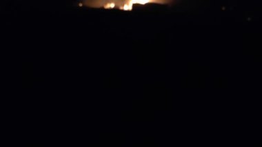 Gece parlayan bir ateş, insanların siluetleri, itfaiyecilerin işi, yavaş çekim