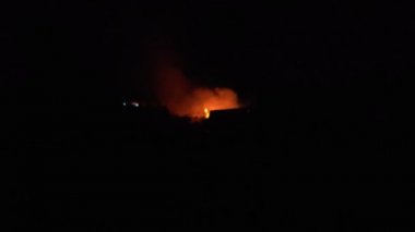Gece parlayan bir ateş, insanların siluetleri, itfaiyecilerin işi, yavaş çekim