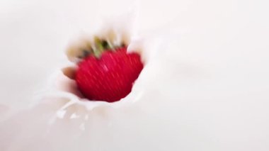 Çilekler narin kremanın içine düşer. yavaş çekim
