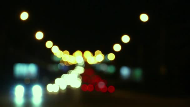 Zamazane światła samochodowe na skrzyżowaniu dużego nocnego miasta — Wideo stockowe