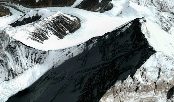 O topo e sopé do monte Everest no Himalaia a partir de uma altura de voo — Fotografia de Stock