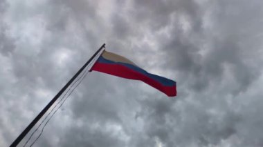 Rusya 'nın ulusal bayrağı rüzgarda bulutlara karşı gelişiyor. Yavaş çekim