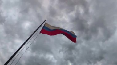 Rusya 'nın ulusal bayrağı rüzgarda bulutlara karşı gelişiyor. Yavaş çekim