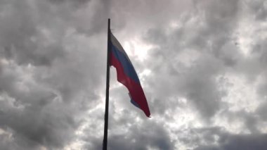 Rusya 'nın ulusal bayrağı rüzgarda bulutlara karşı gelişiyor. Yavaş çekim
