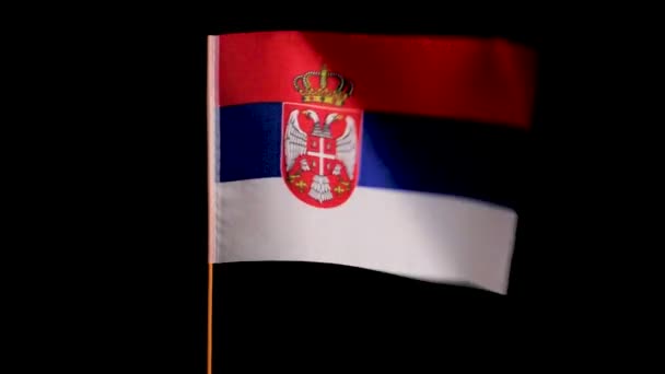Nationell flagga Serbien flyger i vinden på en svart bakgrund — Stockvideo