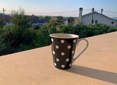 Sabahın erken saatlerinde yerel bir köyde uyanıp günün dingin ve dingin havasının tadını çıkarmak için bir fincan kahve.