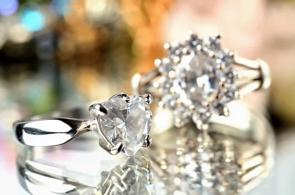 Крупный план серебряного кольца с искусственным камнем и еще одно кольцо на заднем плане - ювелирные изделия, баланс теплых цветов — стоковое фото