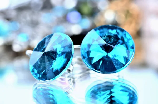 Primo piano di gioielli orecchini blu - effetto riflessione - sfondi colorati — Foto Stock