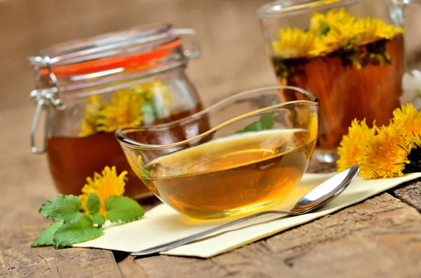 Pampeliškový med, bylinné čaje, plné sklenice medu, Jarní květina, koriandru, lžíce a pampeliška hlava kolem - svačinka — Stock fotografie
