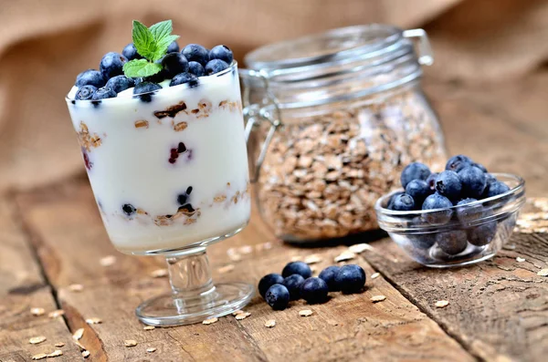 Hausgemachter Joghurt mit Haferflocken, frischen Blaubeeren und Minzblättern — Stockfoto