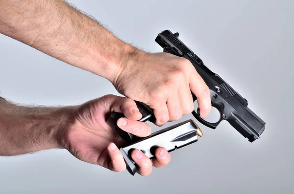 Detalj av mans hand omlastning pistol efter fotografering — Stockfoto