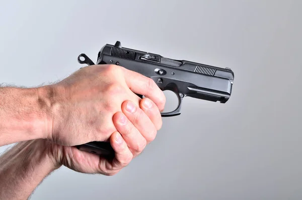 Handen på man siktar med en pistol - sidovy — Stockfoto