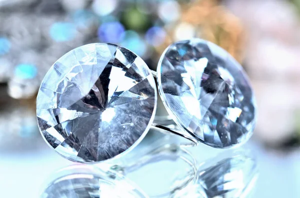 Close-up of transparent earrings jewels - reflection effect - colored backgrounds — Stock Photo, Image