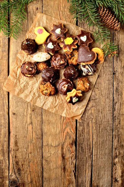 Visa från ovan av julgodis med olika typer av godis på bakplåtspapper på rustika träbord — Stockfoto