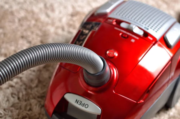 Aspirador en alfombra lanuda - primer plano de hoover rojo moderno — Foto de Stock