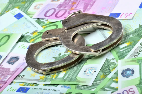 Αστυνομικές χειροπέδες στα τραπεζογραμμάτια ευρώ - έννοια της χρηματοδότησης και της εγκληματικότητας — Φωτογραφία Αρχείου