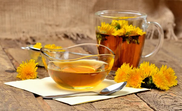 Одуванчик мед, травяной чай, ложка и одуванчик голову вокруг Стоковое Изображение