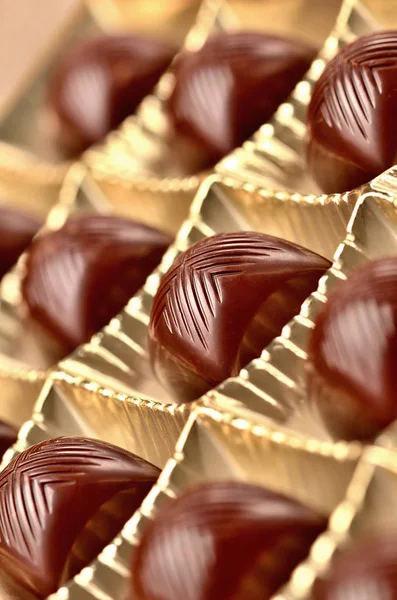Nærbilde av kirsebærsjokolade i konfekteske med et kremfylt, vertikalt bilde av spriten – stockfoto