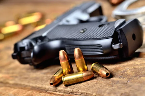 Крупним планом 9 мм пістолет, кулі та наручники — стокове фото