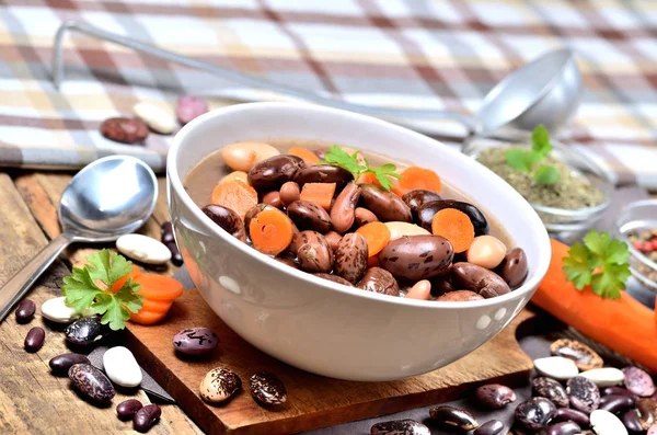 Bohnensuppe mit großen Bohnen, Karotten, Petersilie, Majoran, Löffel und Schöpfkelle — Stockfoto