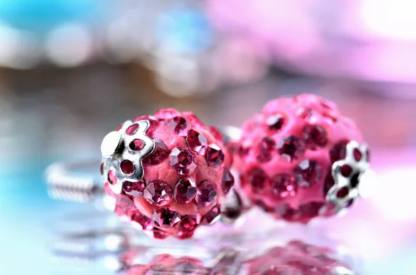 Close-up de brincos vermelhos com jóias de diamantes vermelhos - efeito de reflexão - dois fundos coloridos - azul, roxo — Fotografia de Stock