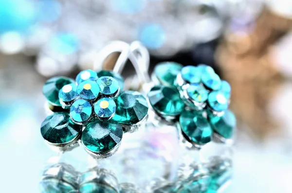 Close-up de brincos em forma de flor verde com jóias de diamantes geeen - efeito de reflexão - fundos coloridos — Fotografia de Stock