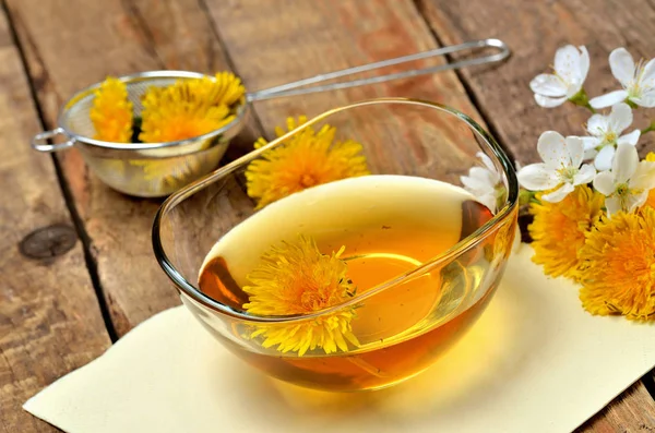 Miel de pissenlit dans un bol en verre et tête de pissenlit autour — Photo