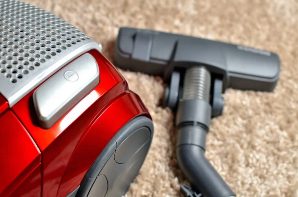 Vacuum cleaner on shaggy carpet - close-up of head noozle and modern hoover