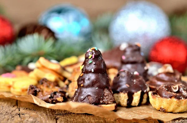 Primo piano di dolci natalizi con diversi tipi di caramelle su carta da forno e decorazioni natalizie — Foto Stock