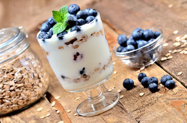 Hausgemachter Joghurt mit Haferflocken, frischen Blaubeeren und Minzblättern — Stockfoto