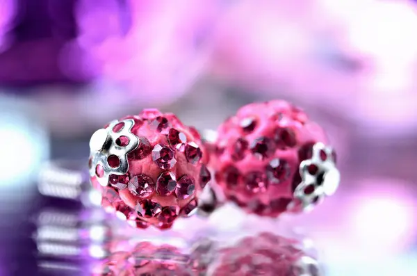 Close-up de brincos vermelhos com jóias de diamantes vermelhos - efeito de reflexão - fundos coloridos - roxo — Fotografia de Stock