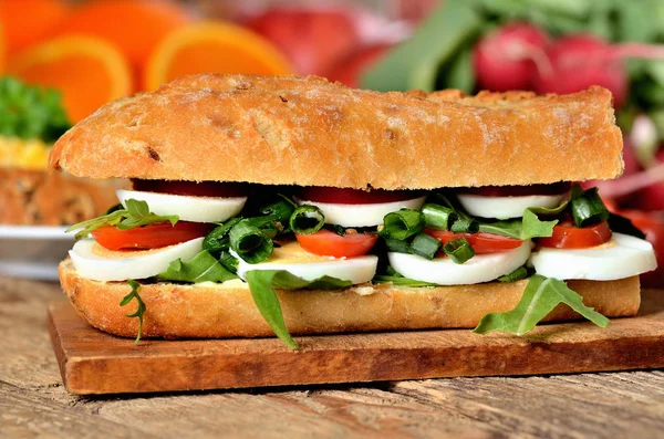 Baguette-Sandwich mit Ei, Rucolasalat, Tomaten und Rettich Stockbild