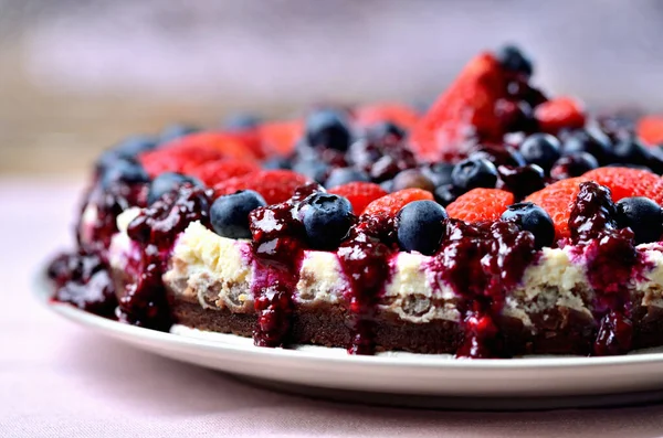 Cheesecake tart with fresh strawberries, blueberries and cherry jam. — Stock Photo, Image