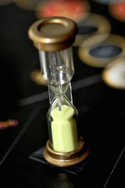 Sanduhr mit Sand auf dem Spielfeld für Brettspiele. — Stockfoto