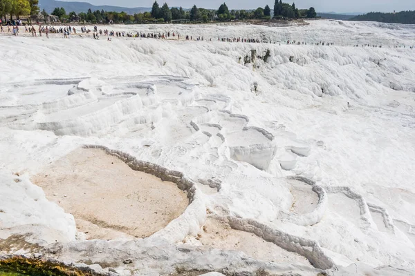Türkiye 'nin Pamukkale kentinde sakin suyla Travertines teraslarında yürüyen turistlerin bulunduğu güzel manzara.