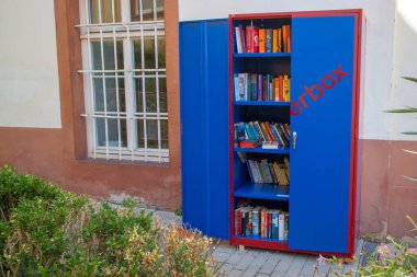 Neckargemuend, Almanya - 18 Ağustos 2019: Güney Almanya 'nın Neckargemuend kentindeki bir evde halka açık bir kitaplık. Kitaplar ücretsiz olarak herkes tarafından çıkarılabilir ya da yerleştirilebilir