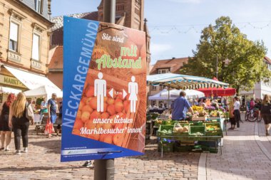 Neckargemuend, Germany: September 20, 2020: Corona warning sign for keeping distance at regional seasonal market in autumn with local products, called 
