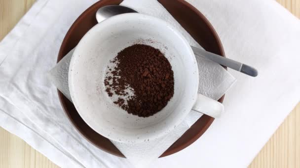 Le café lyophilisé dans la tasse est versé avec de l'eau bouillante. La vapeur chaude remplit le cadre. Faire boire de la caféine noire. Gros plan vue sur le dessus, table en bois, serviette blanche