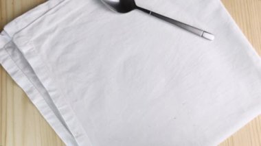 Kapuçino ya da latte. El, kirli bardağı, bitmemiş süt köpüğüyle masaya koyar. Kremalı köpükle iç, tarçın ve kakao tozu serpiştir. Yakın çekim üst manzara, beyaz peçete, ahşap zemin