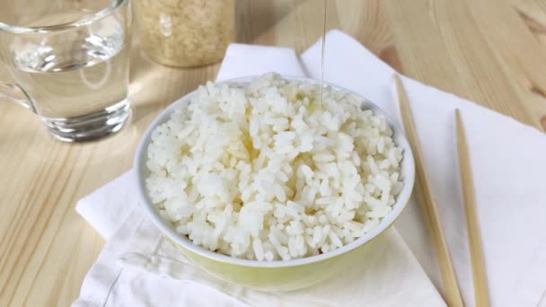 白飯は野菜油で炊かれる 丸いボウルに長い粒米を失う 簡単な食事 アジア料理を調理します クローズアップ 木製のテーブル ナプキン — ストック動画