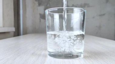 Beyaz kız omzuna bej sütyen takıyor. El sütyen ayarlıyor. Kadın iç çamaşırlarını giydirme süreci. Yakın plan. Beton duvar arkaplanı