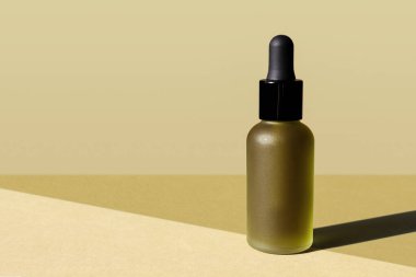 Donmuş yağ şişesi, siyah pipet, çimenli yeşil arka plan. Yatay afiş, poster, kopyalama uzayı. Güzellik camı ambalajı. Organik eko kozmetik serumu, kenevir özü, emülsiyon, bitkisel losyon.