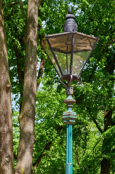 Historic street lamp that was powered by gas and stands in a Berlin park.