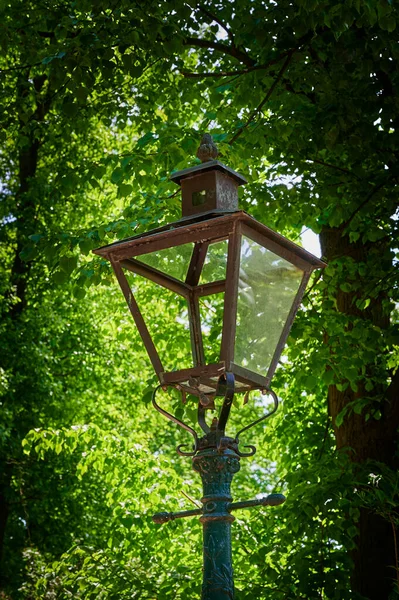 Historic street lamp that was powered by gas and stands in a Berlin park.
