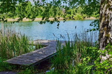 Almanya 'nın Sperenberg yakınlarındaki bir gölün üzerinde mavi ve bulutlu bir gökyüzü.