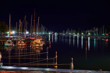 Greifswald, Almanya - 30 Ağustos 2020: Mavi saatte yansıyan ışıklarla Greifswald yelken limanının manzarası.