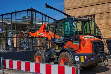 Berlin, Almanya - 9 Nisan 2020: Dresden demiryolu hattında inşaat alanı. Eski bir cam bisiklet kulübesini söken işçilere destek veren bir kazıcı görüyorsunuz..