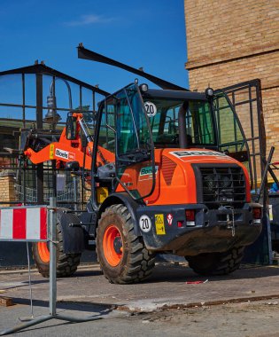 Berlin, Almanya - 9 Nisan 2020: Dresden demiryolu hattında inşaat alanı. Eski bir cam bisiklet kulübesini söken işçilere destek veren bir kazıcı görüyorsunuz..